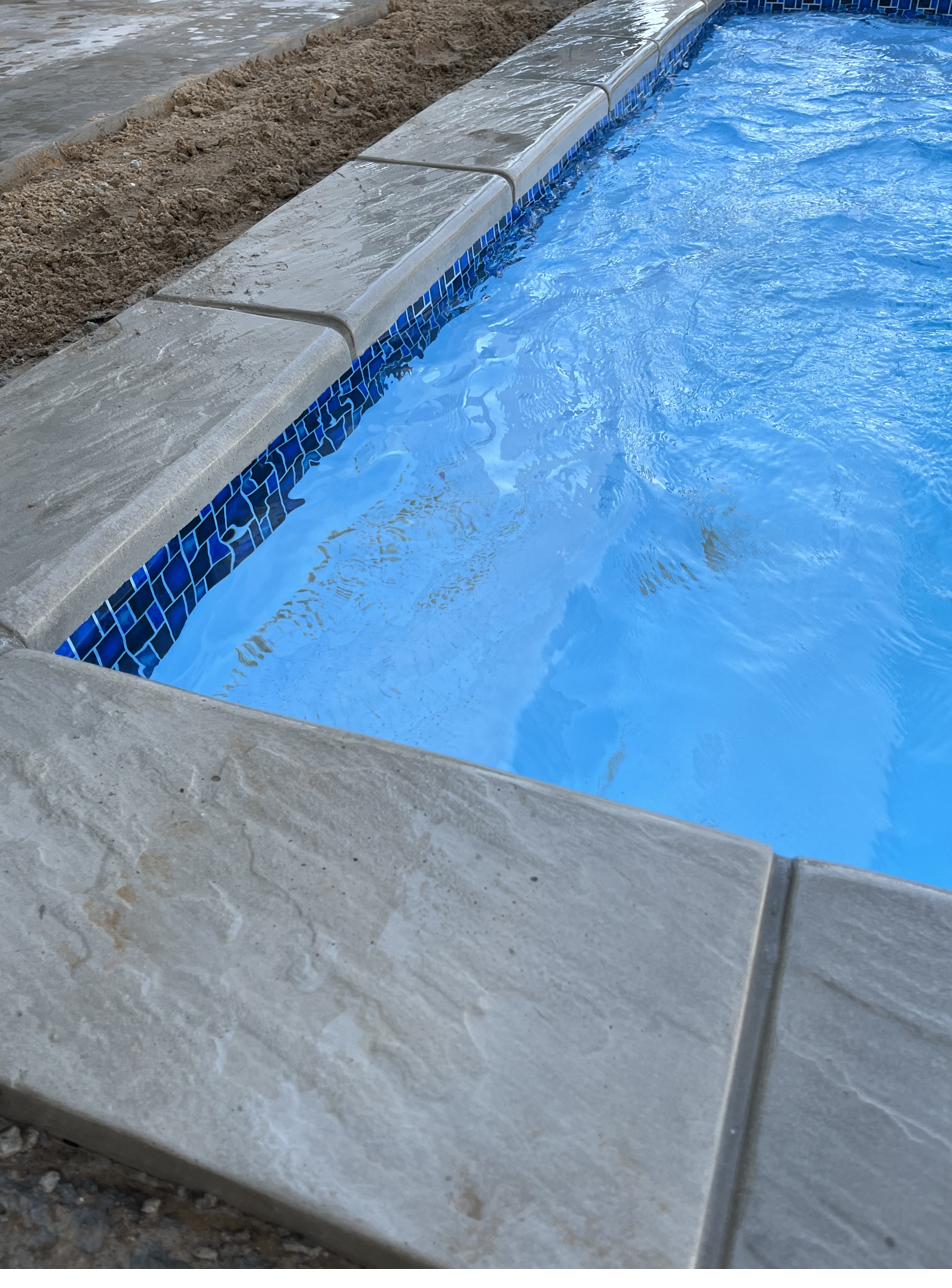 SanStone pool coping with a bullnose edge around a swimming pool