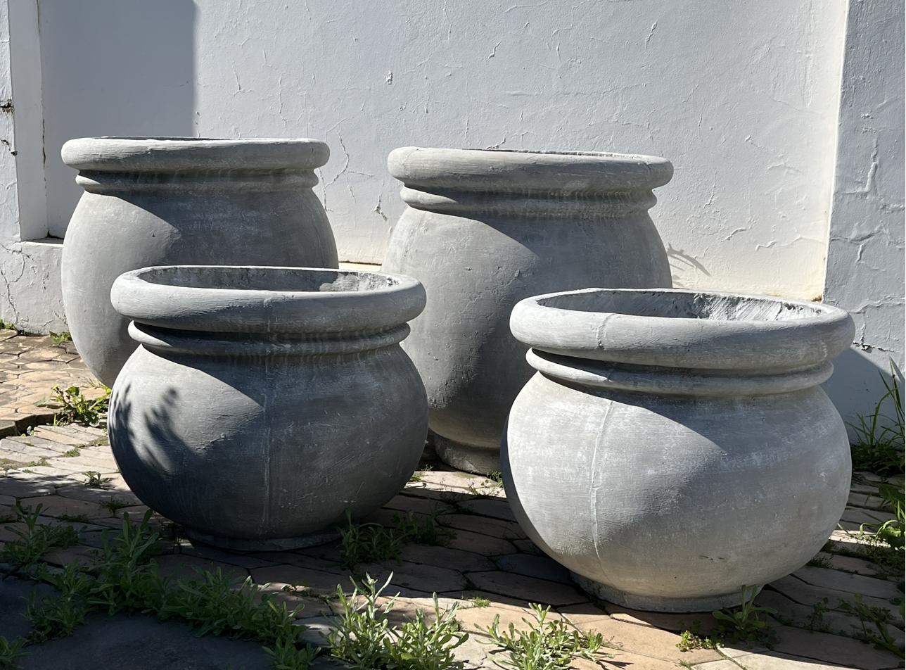 Four round bellied cement pots